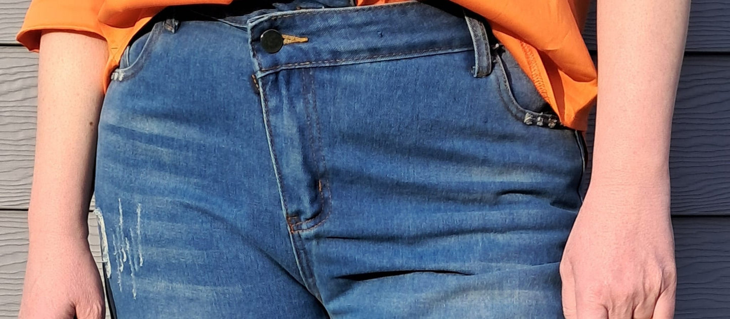 Jeans met subtiele scheuren en brede omslag onderaan en schuine rits
