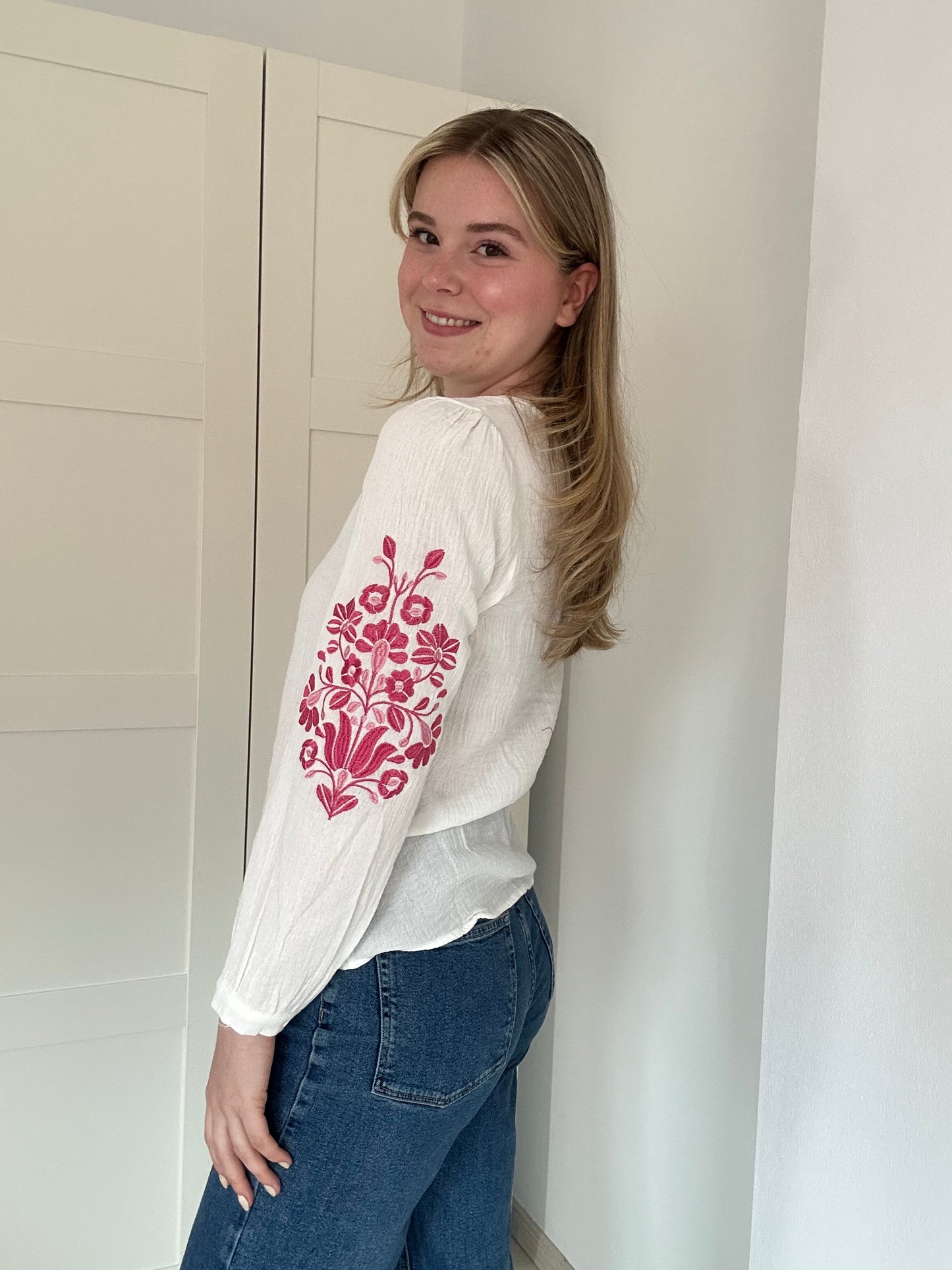 Luchtige, witte bloes met bloemmotief op mouw