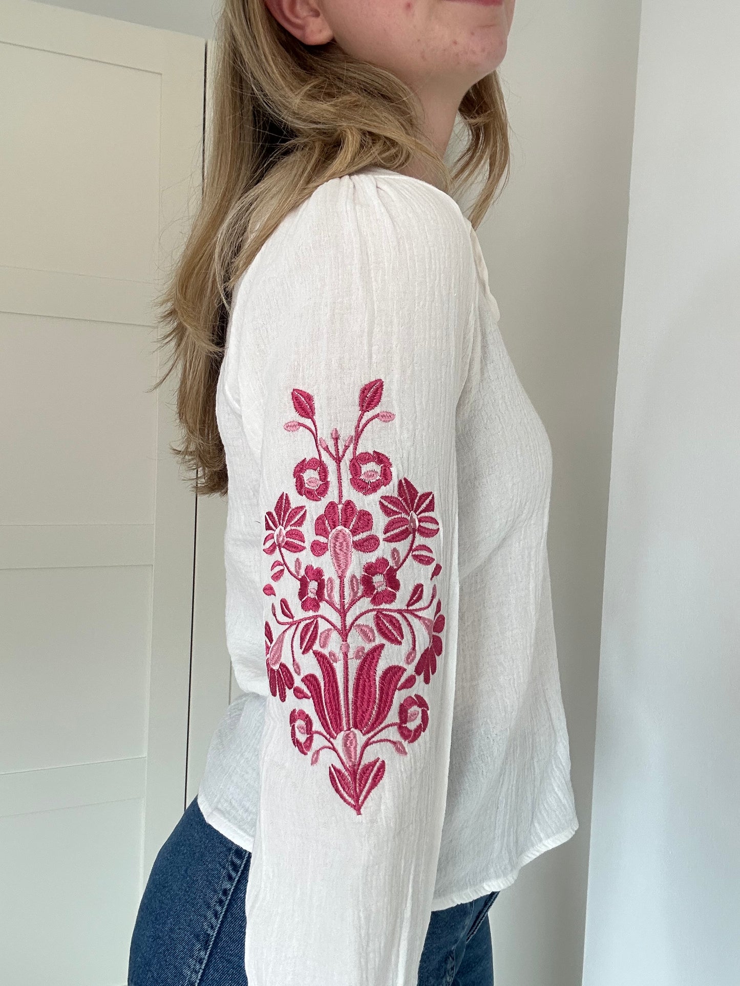 Luchtige, witte bloes met bloemmotief op mouw