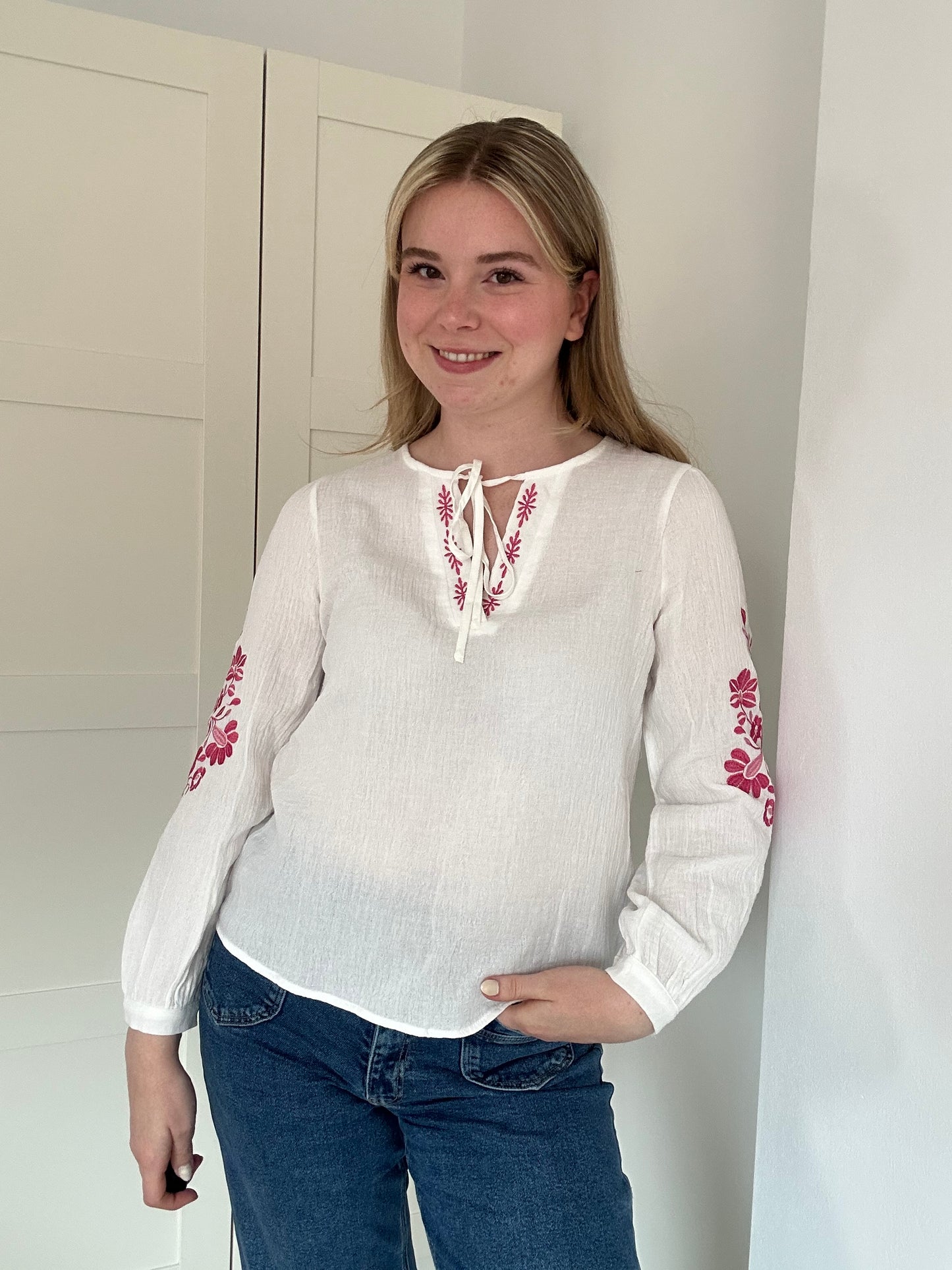 Luchtige, witte bloes met bloemmotief op mouw