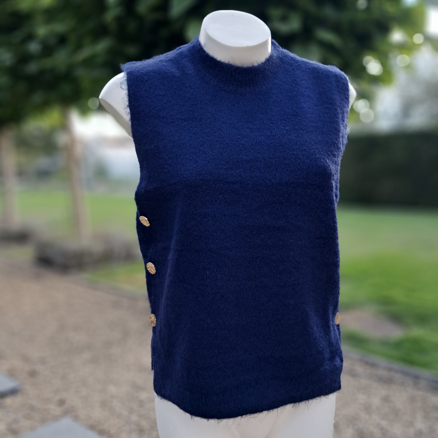 Zachte, mouwloze trui (debardeur) met gouden knopen aan de zijkant