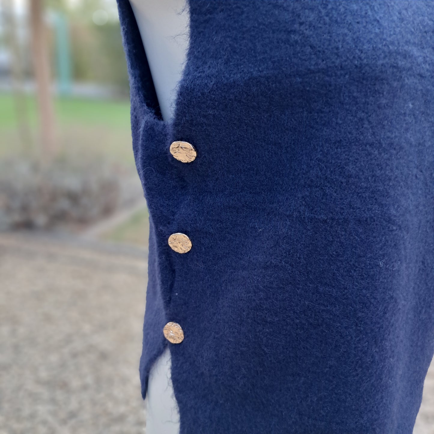 Zachte, mouwloze trui (debardeur) met gouden knopen aan de zijkant