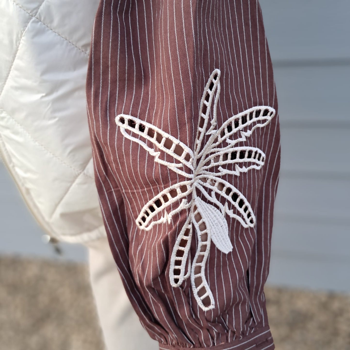 Mooie blouse met strepen en decoratief bloemmotief op de mouw.