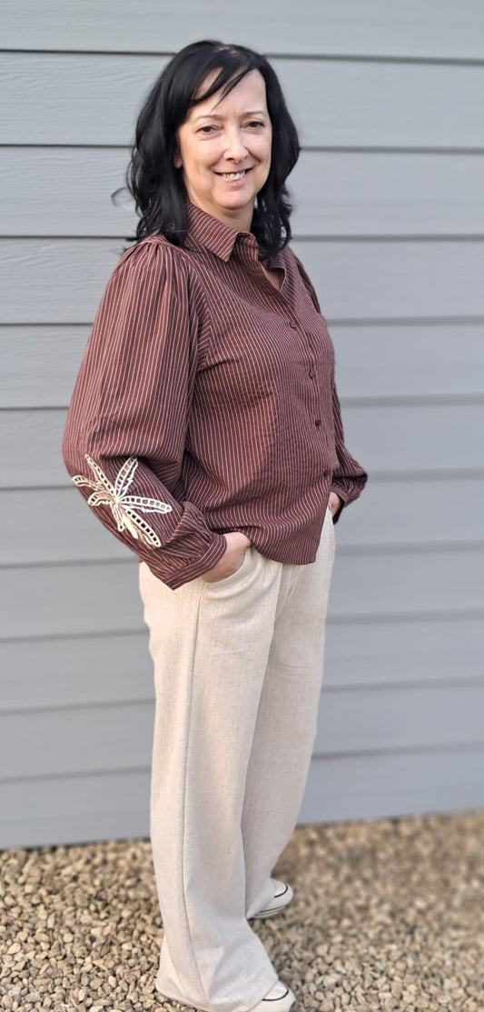 Mooie blouse met strepen en decoratief bloemmotief op de mouw.