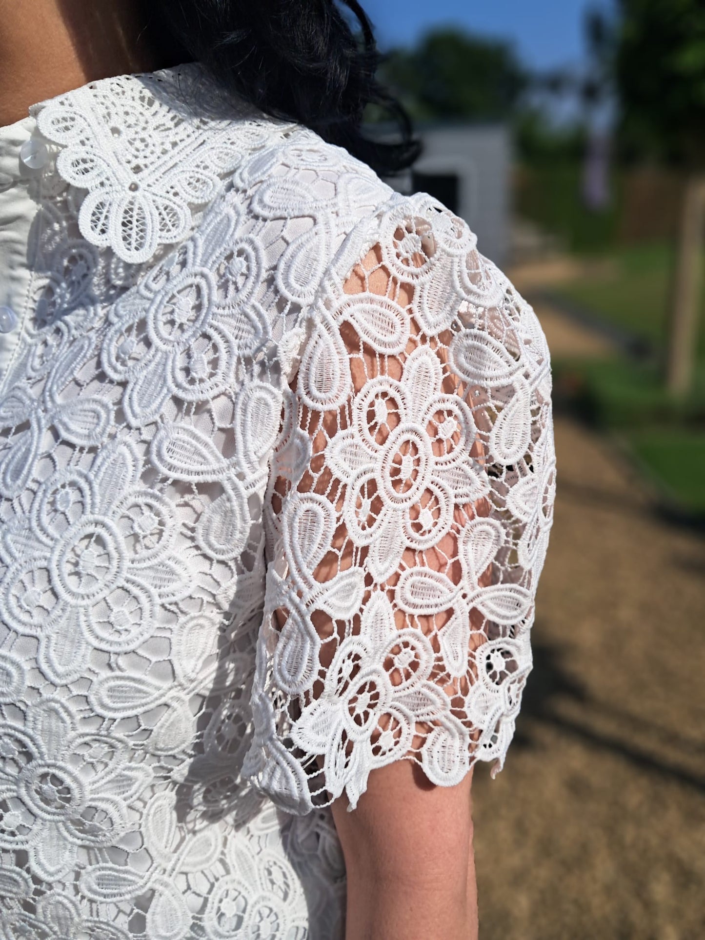 Elegante damesblouse in wit uit kantstof met bloemmotief