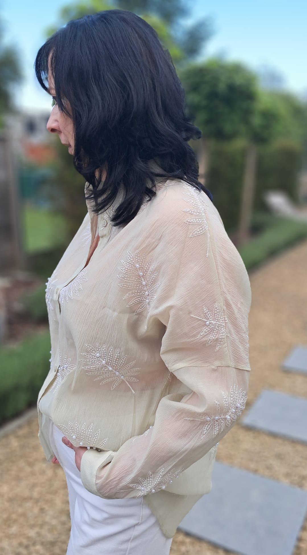 Lichtgroene, transparante blouse met geborduurde bladmotieven, afgewerkt met pareltjes